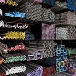 Various angle iron profiles and steel rods kept in storage shelves in a steel shop.